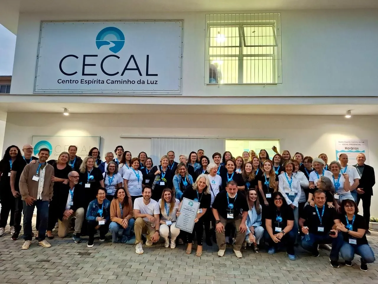 O grupo da casa reunido em frente à sede, sob a placa do CECAL — Centro Espírita Caminho da Luz.